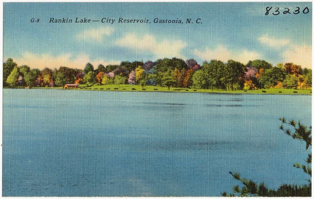 Lake with trees along the horizon, water in the foreground. Text: