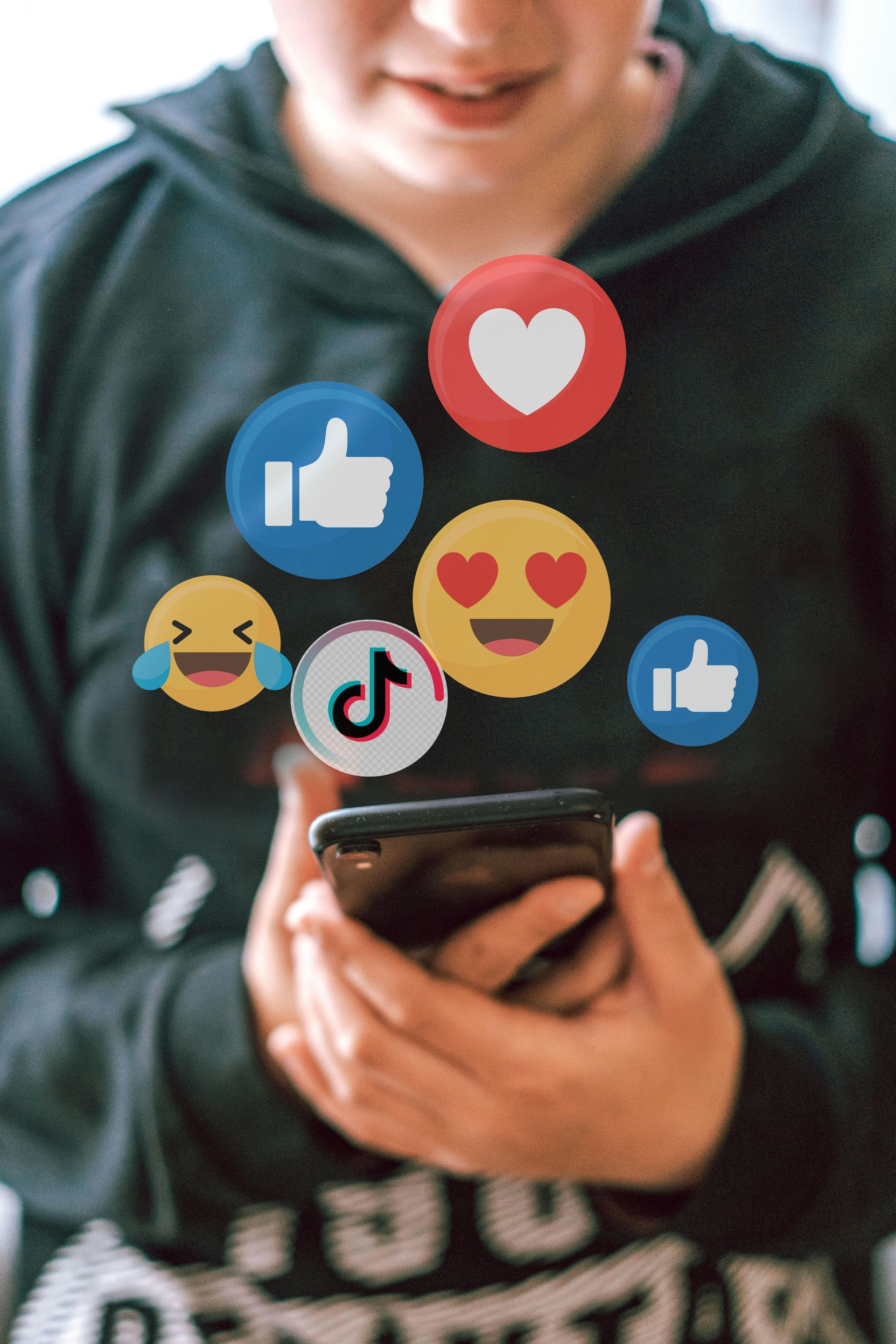A person holds a smartphone, surrounded by floating social media reaction icons and a TikTok logo.