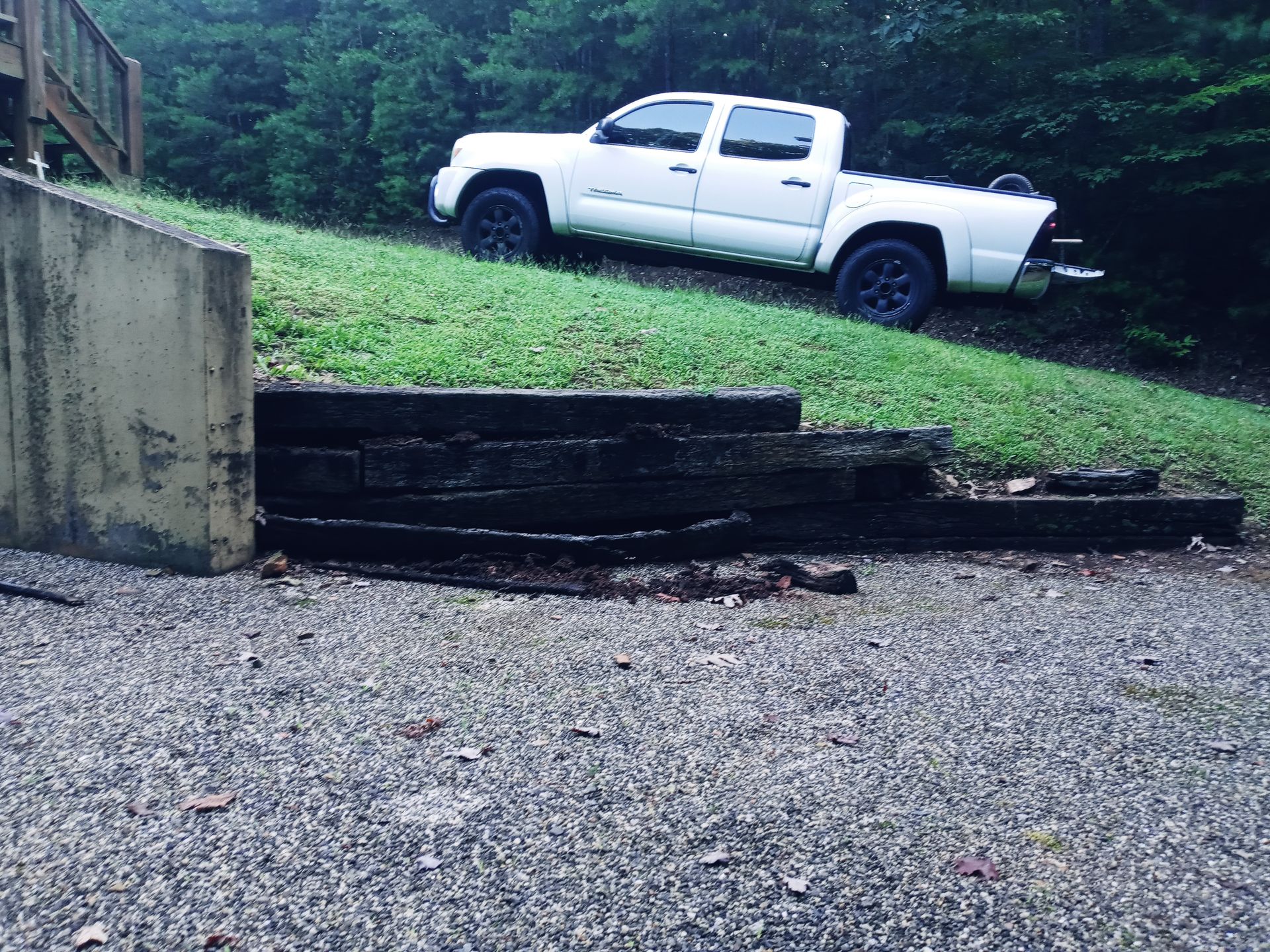 A white truck is parked on the side of a hill