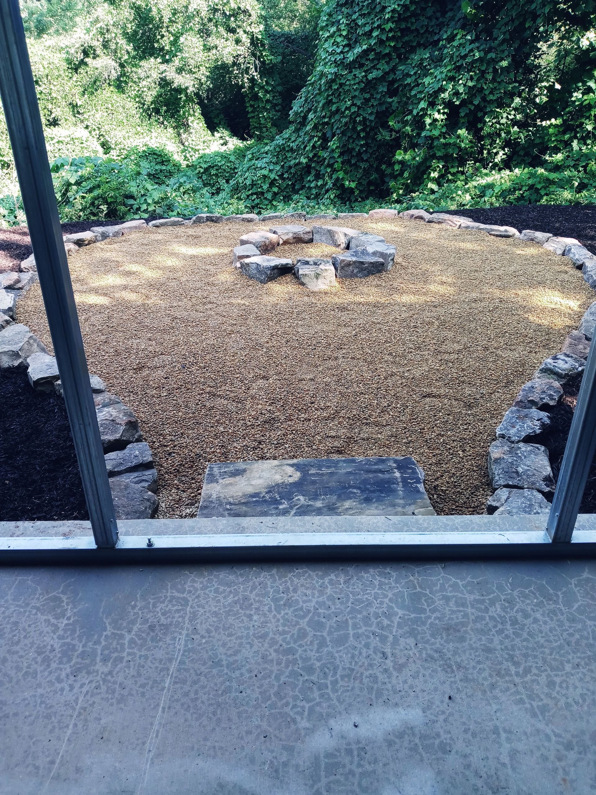 A fire pit is sitting in the middle of a gravel area.
