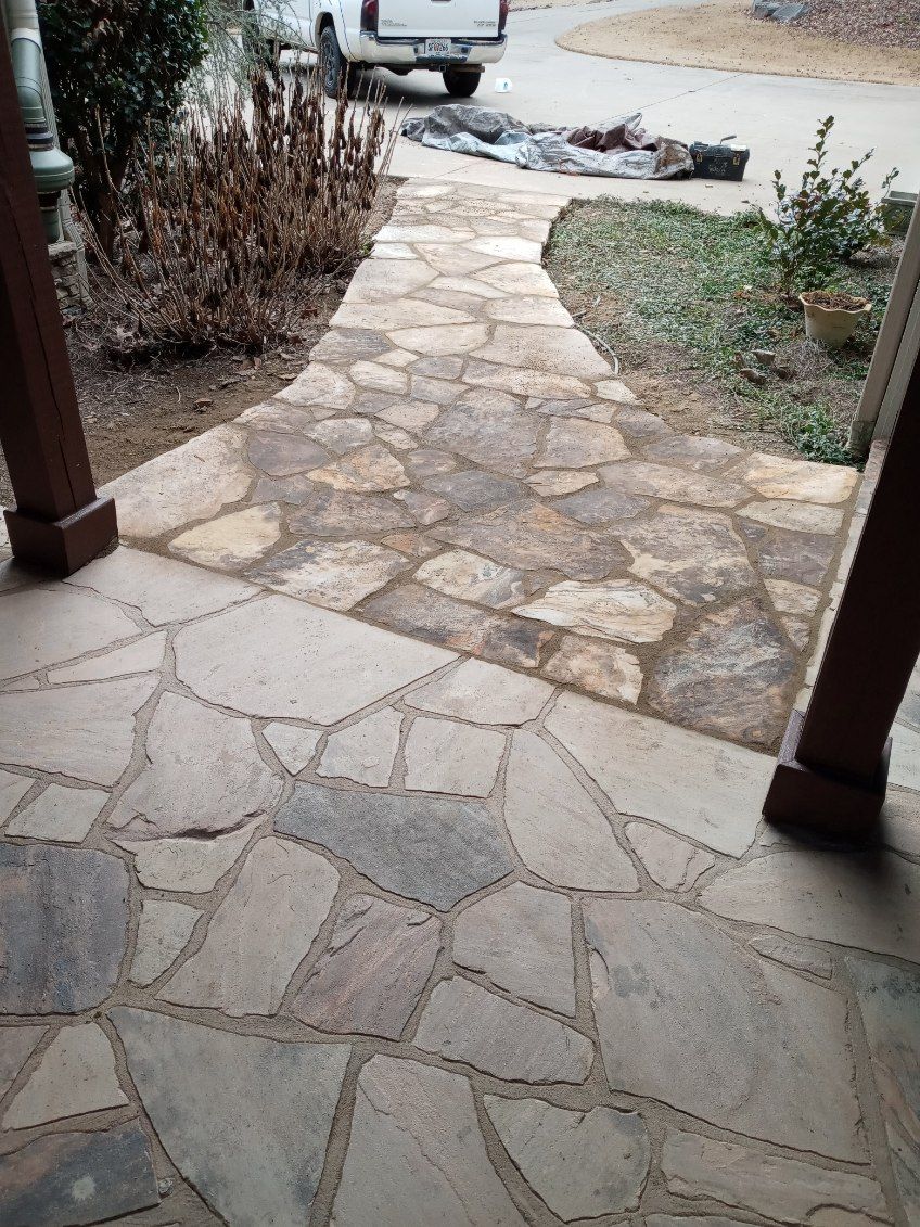 A stone walkway leading to a house in the woods
