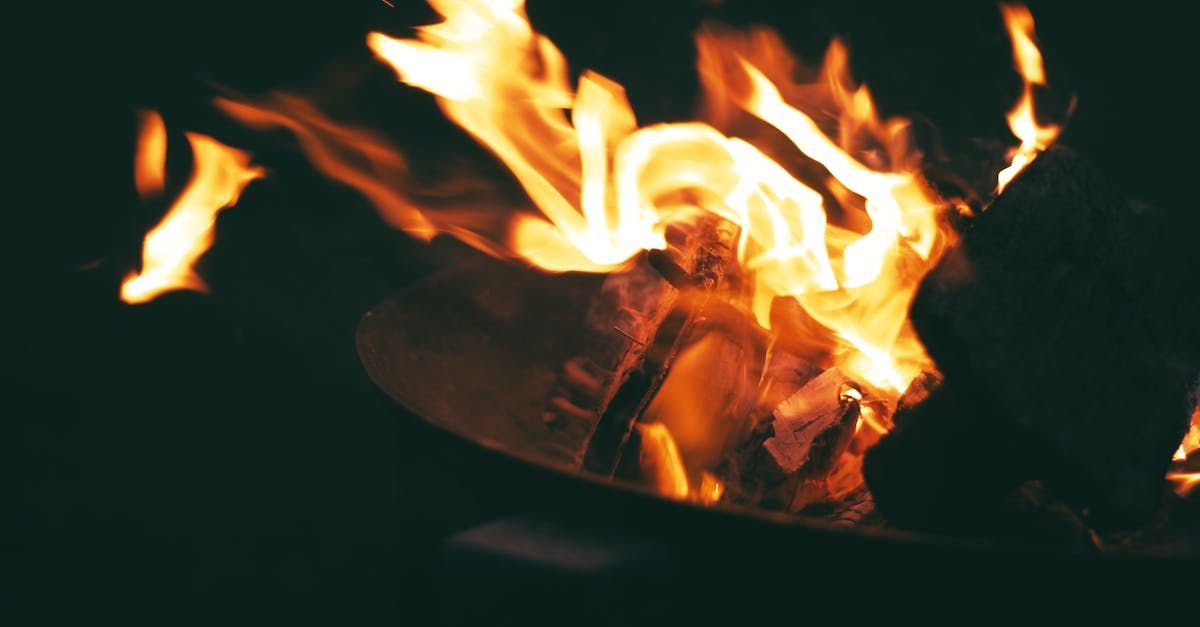 A close up of a fire in a fire pit at night.
