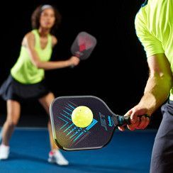 Zwart pickleball racket met een turquoise geometrisch logo en een zwarte grip op een witte achtergrond.