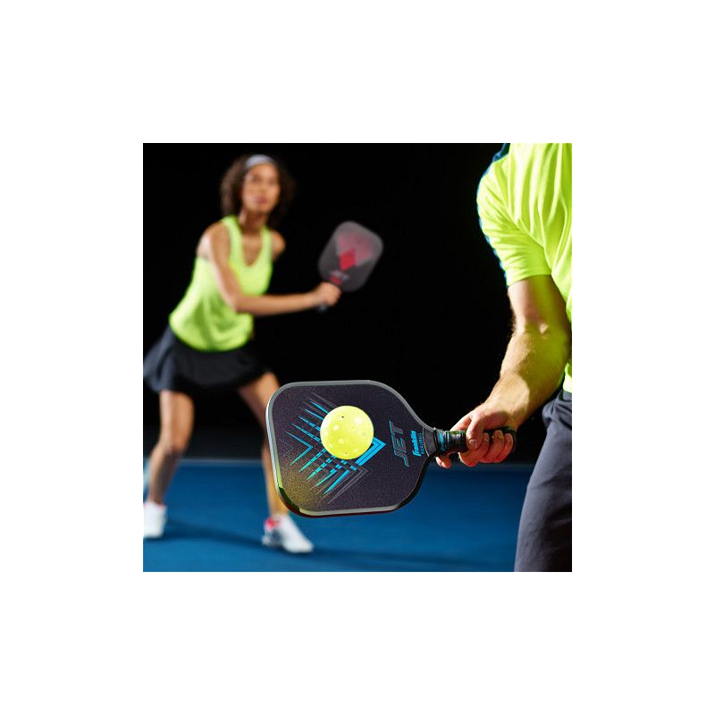 Twee zwarte pickleball rackets, een blauwe en een rode, met twee gele ballen op een witte achtergrond.
