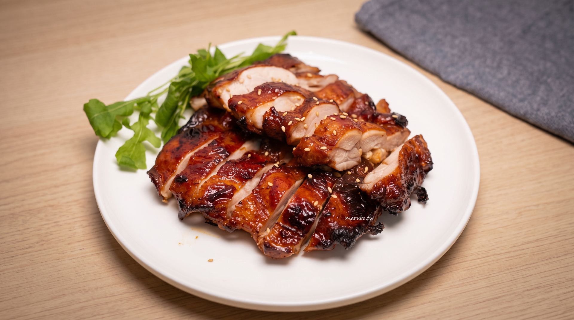 Glazed grilled chicken on a white plate with parsley garnish