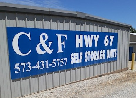 Blue sign on a storage building reads &ldquo;C&F Hwy 67 Self Storage Units&rdquo; with phone number 573-431-5757