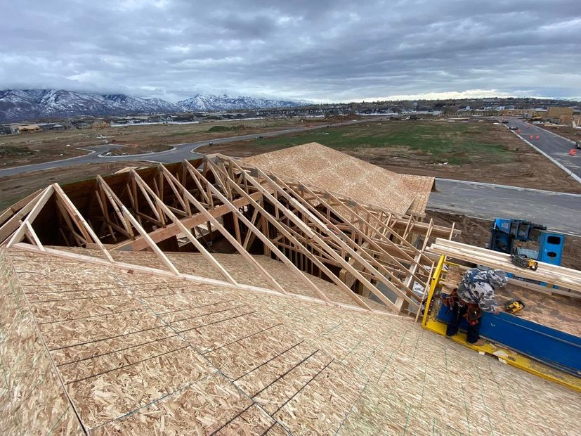 A large wooden structure is being built on top of a hill.