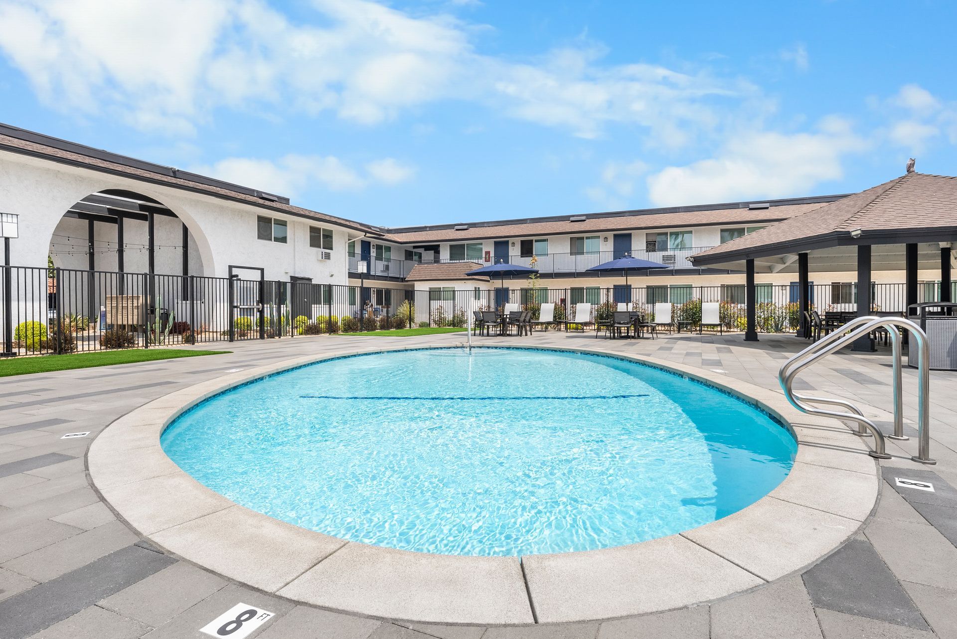 Swimming pool surrounded by two story apatment building