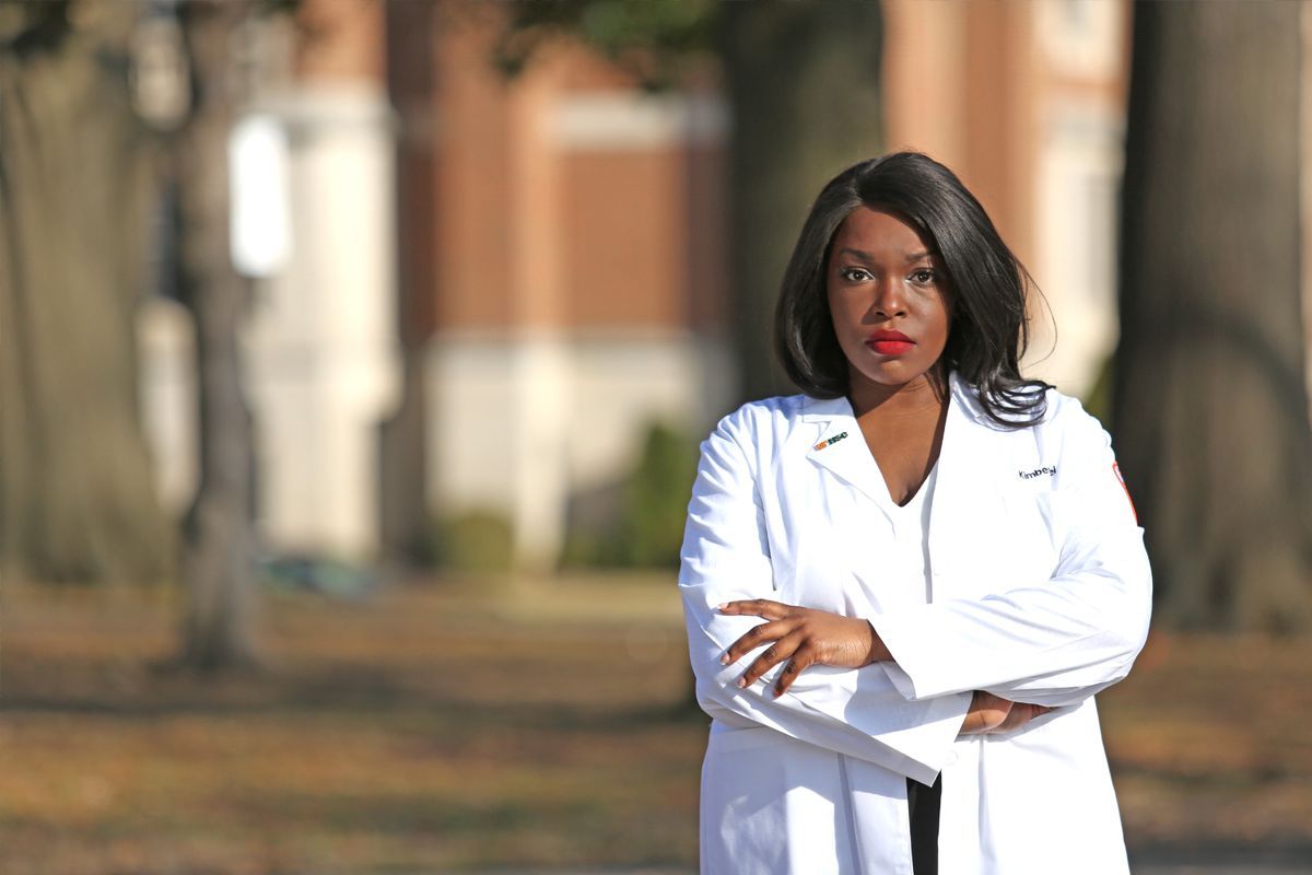 Kimberly Diei wearing a white doctor's coat.