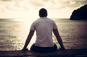 man in front of body of water