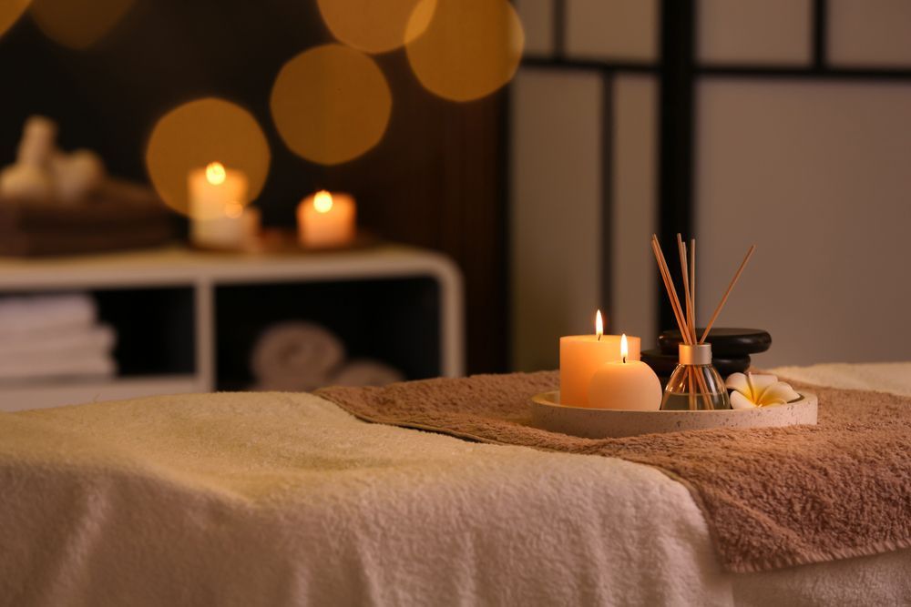 A massage table with candles and reed diffusers on it in a spa.