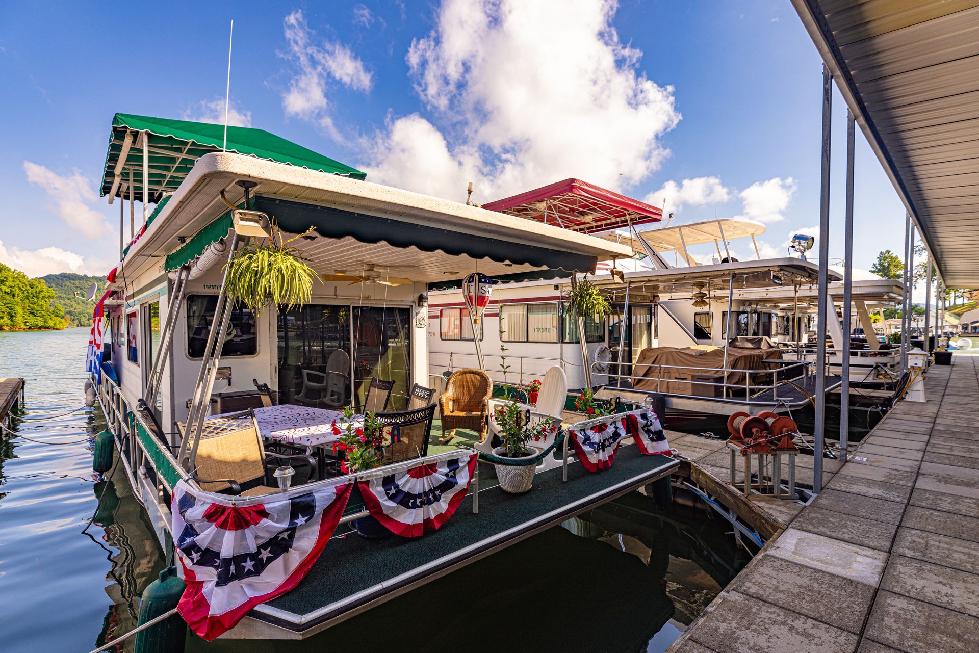 Houseboats docked at the marina, with patriotic bunting on the front deck