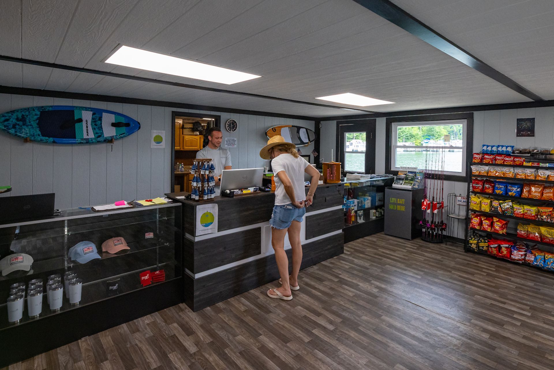 Customer at the checkout counter inside the marina store, with snacks and apparel on display