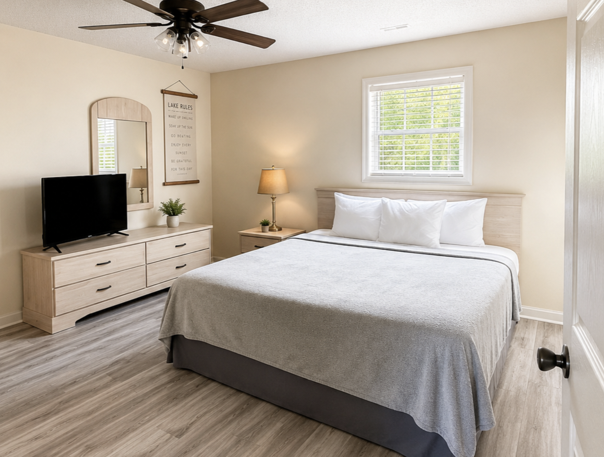 Bedroom with a king bed, dresser, TV, and ceiling fan