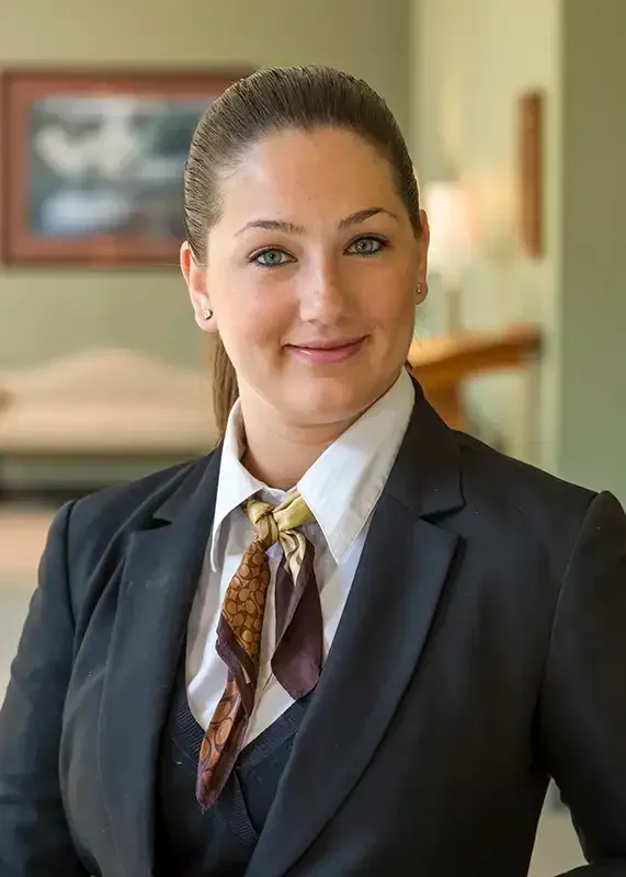 Woman in suit and tie, smiling, indoors.