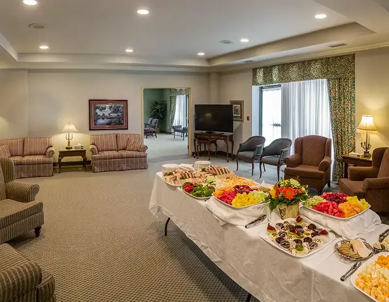 A funeral reception room with food buffet; sofas and chairs.