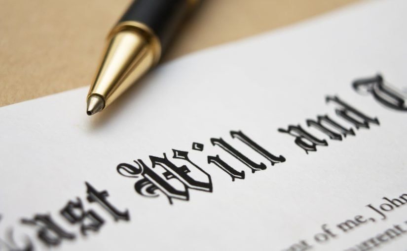 Close-up of a will document with a pen resting on the paper.