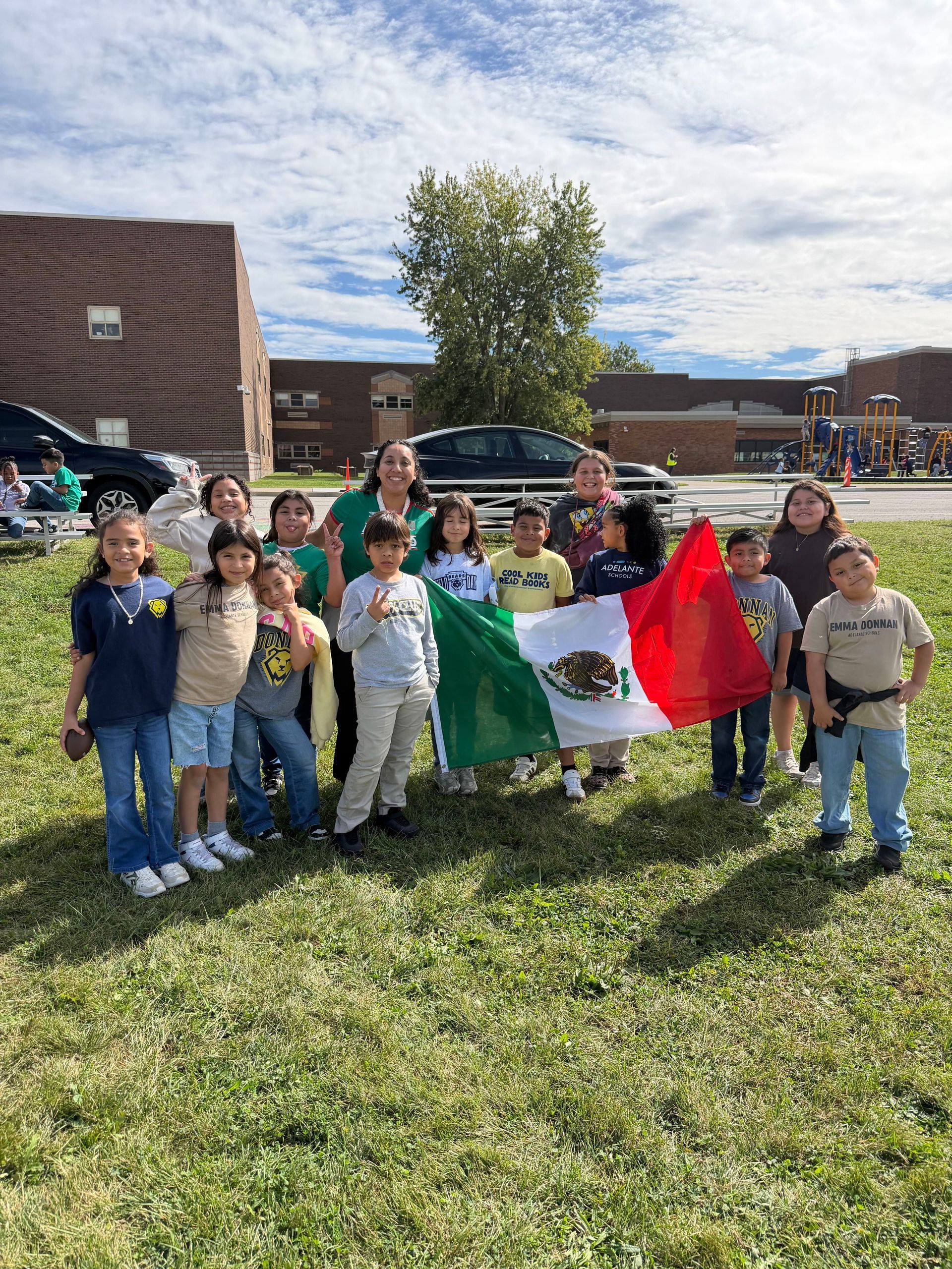 A group of scholars smiling and holding a Mexican flag during Hispanic Heritage Month