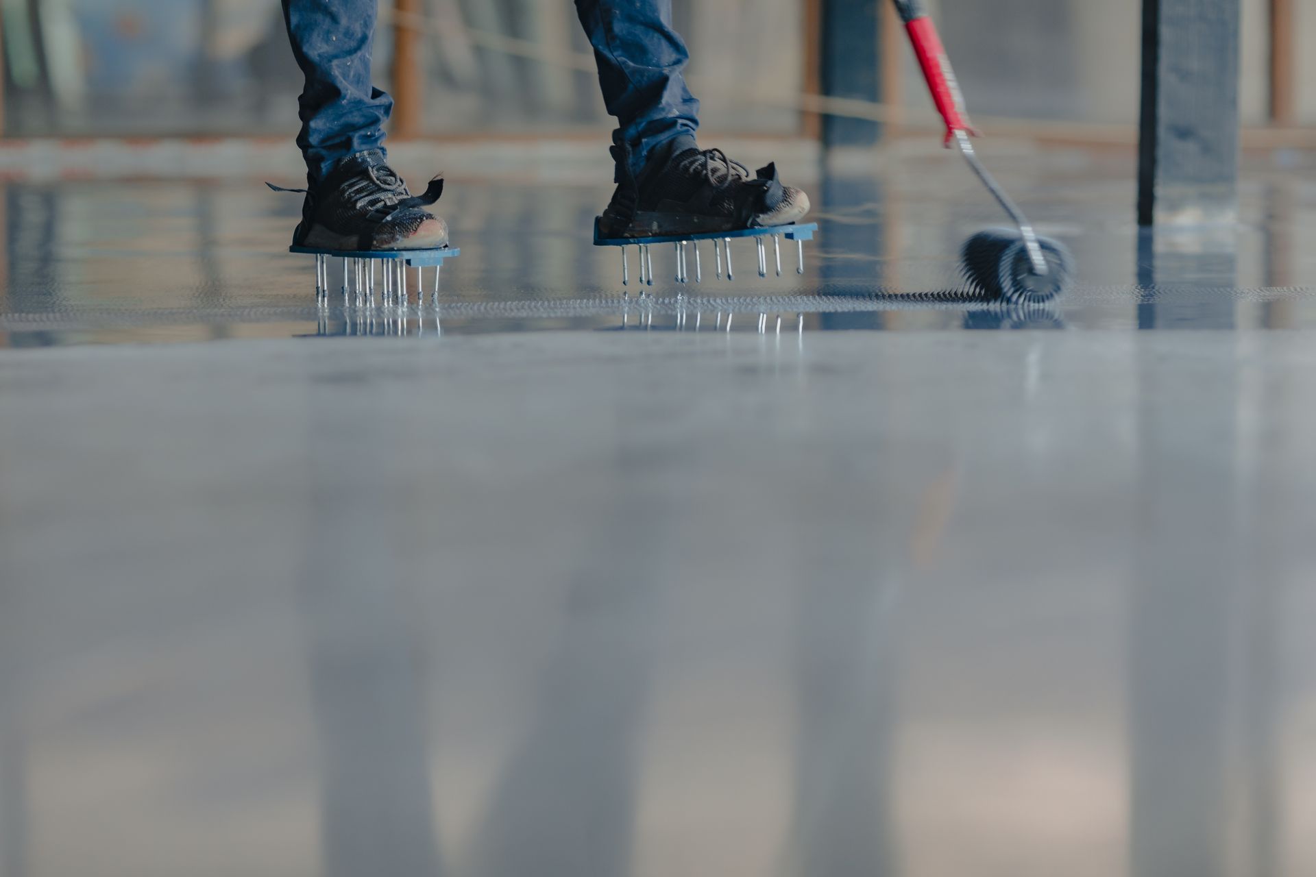 two men are working on a concrete floor in a room .