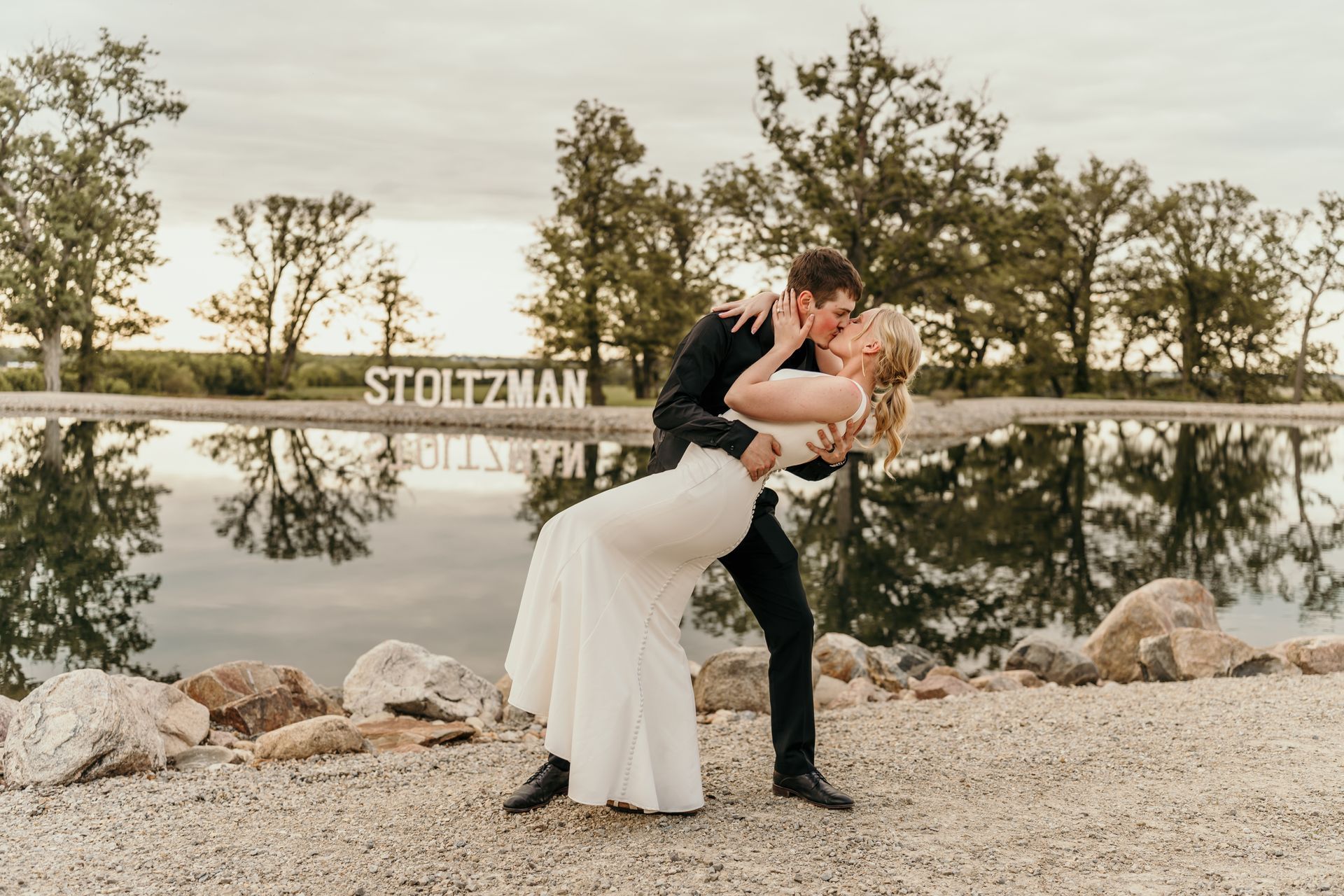 Bride and groom sharing a romantic kissing near a pond in Joice, IA on their wedding day.