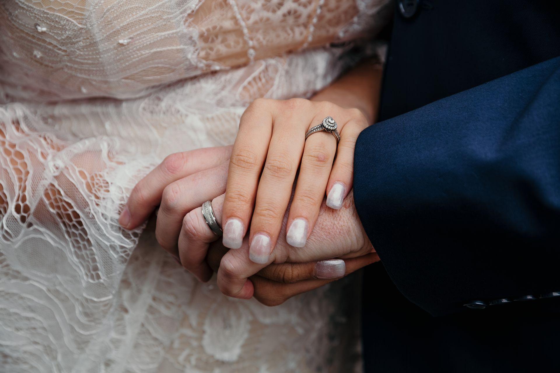 Bride and groom displaying their wedding rings during a portrait session in Pella, IA.
