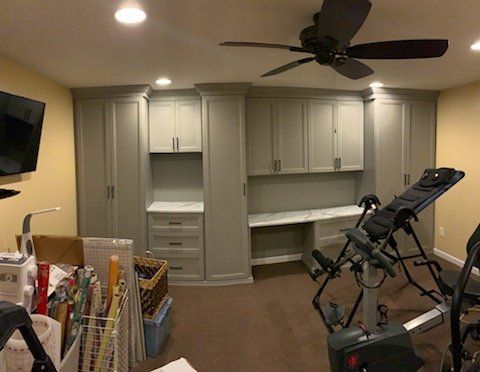 A room with a ceiling fan and a treadmill in it.