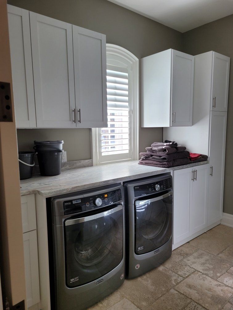 A laundry room with a washer and dryer and a window.