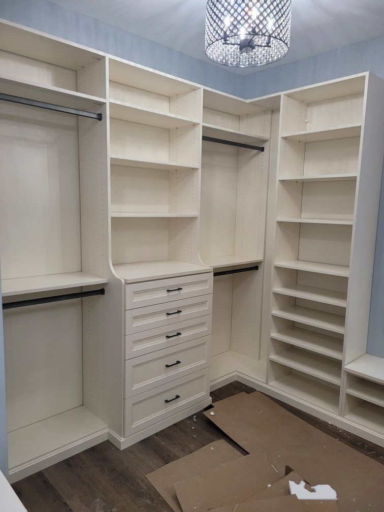 A walk in closet with lots of shelves and drawers