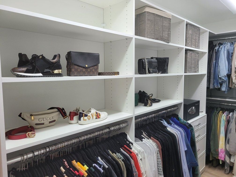 A walk in closet filled with clothes and shoes.