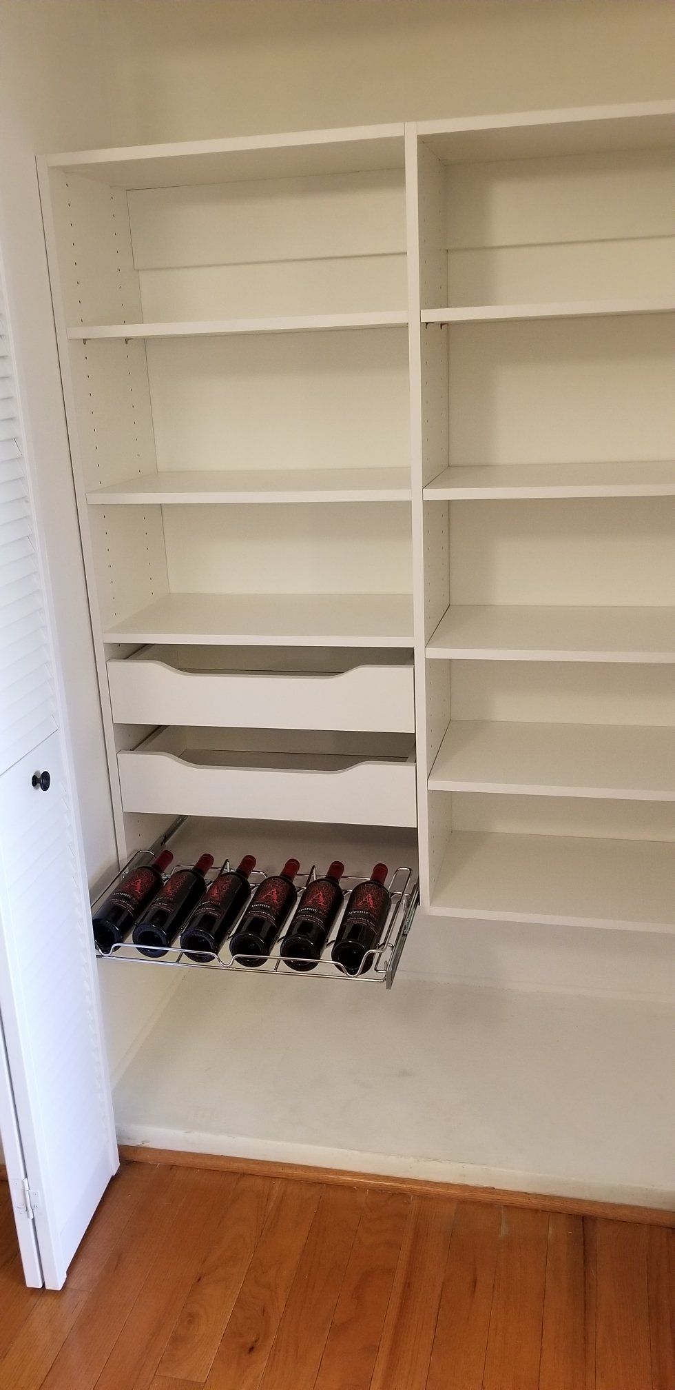 A closet filled with lots of shelves and bottles of wine.