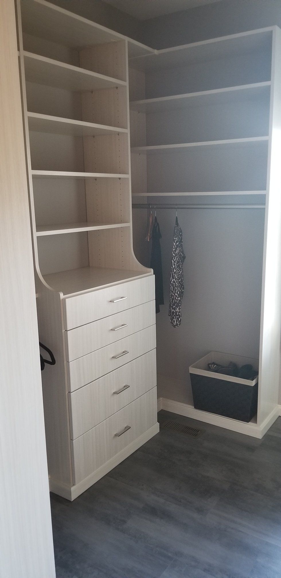 A walk in closet with lots of shelves and drawers.