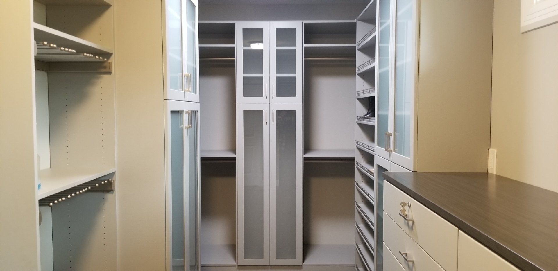 A walk in closet with lots of shelves and drawers