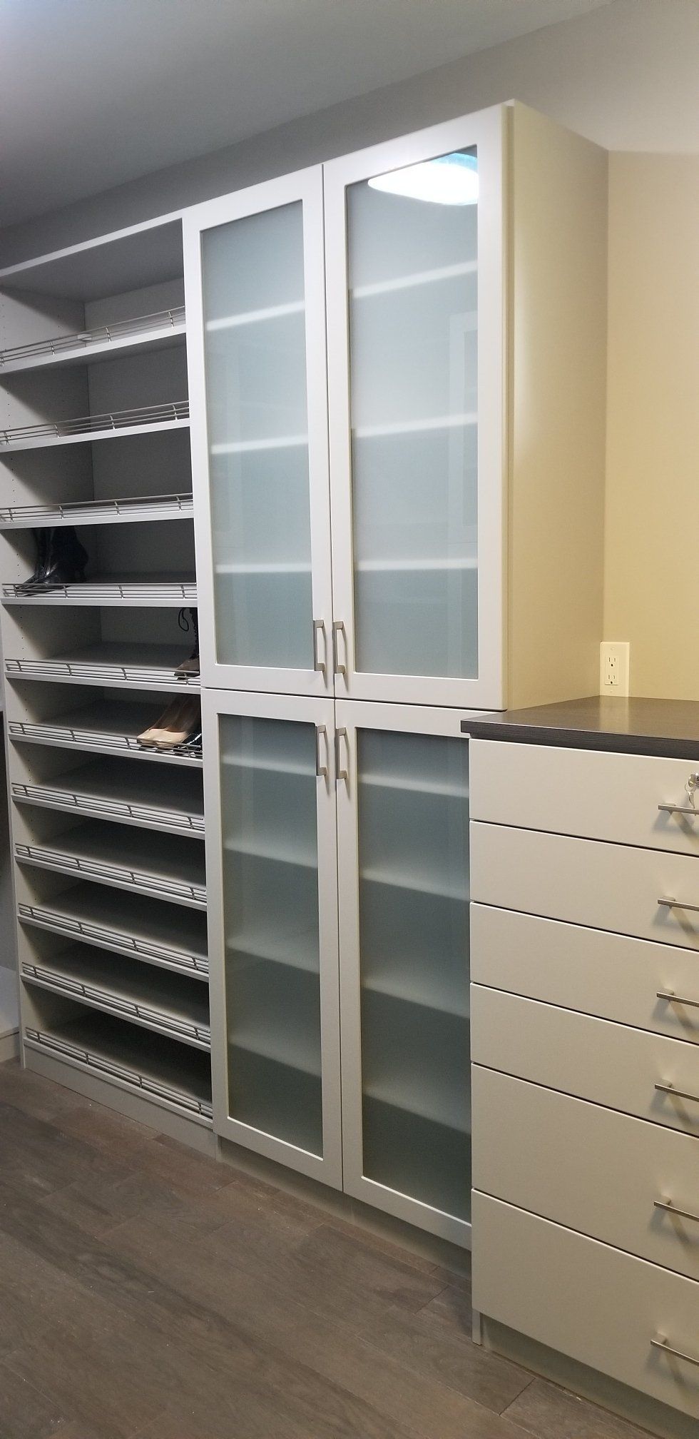A walk in closet with lots of shelves and drawers.
