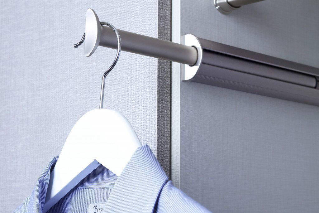 A shirt is hanging on a white hanger in a closet