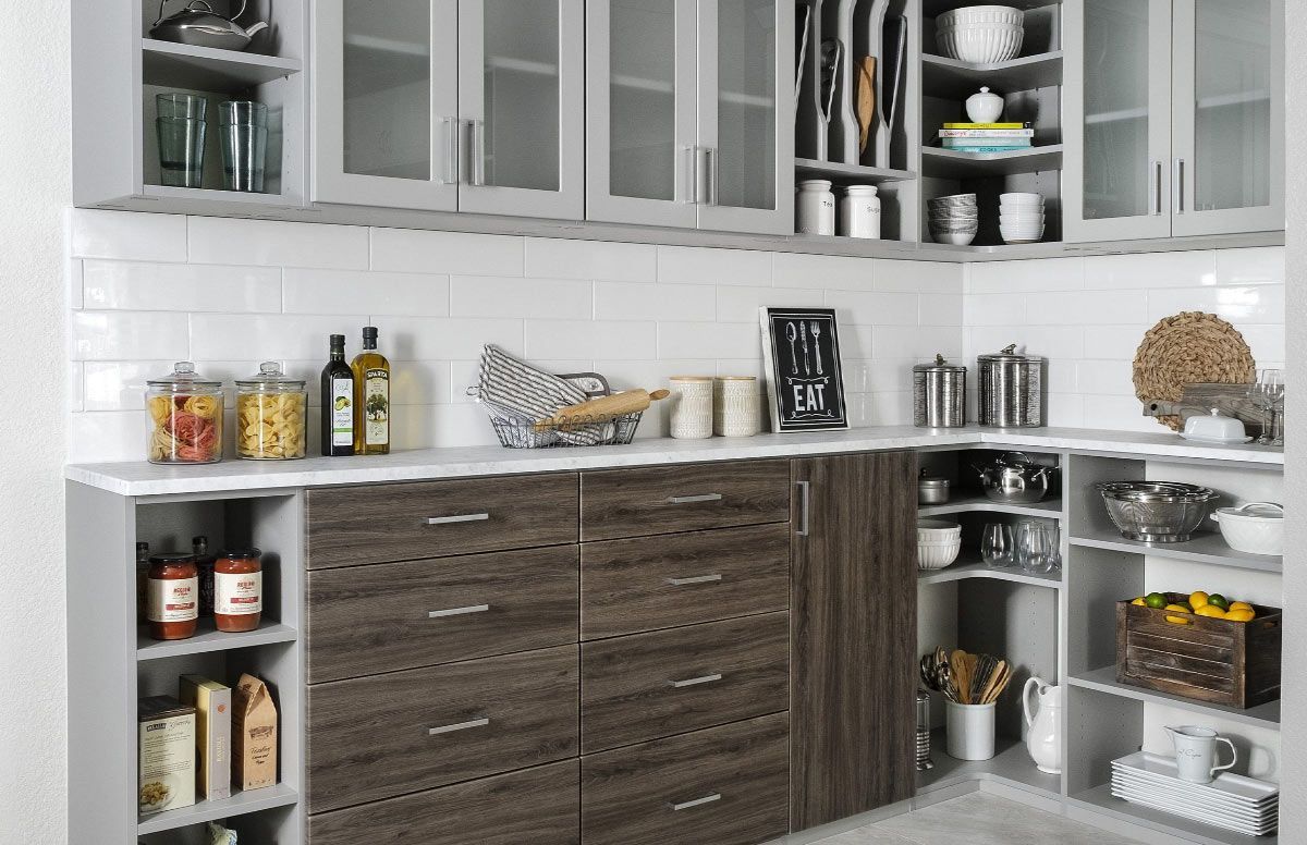 A kitchen with lots of cabinets and shelves and a pantry.