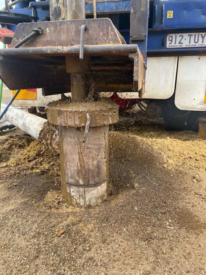 A white semi truck is parked on a dirt road