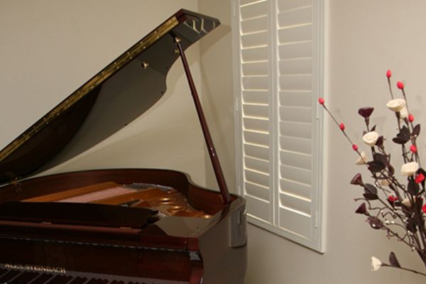 White Shutter Window And A Piano — Wholesale Window Coverings in Lake Macquarie, NSW