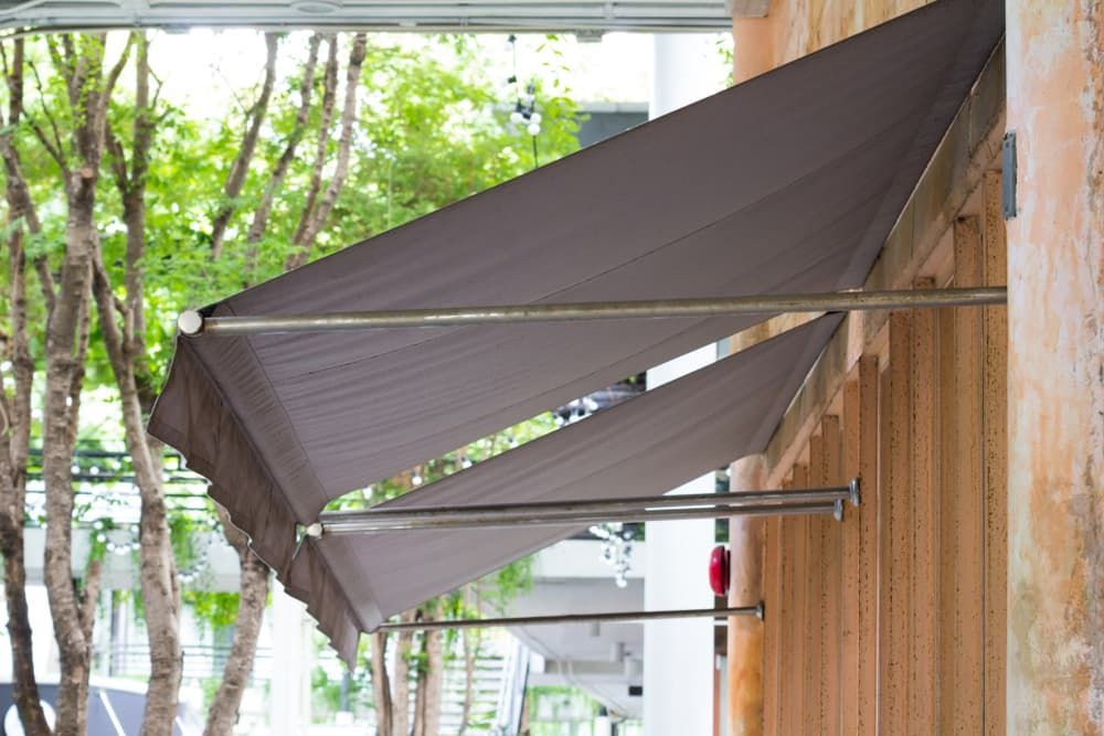 Brown Fabric Awnings Extend From a Textured Wall