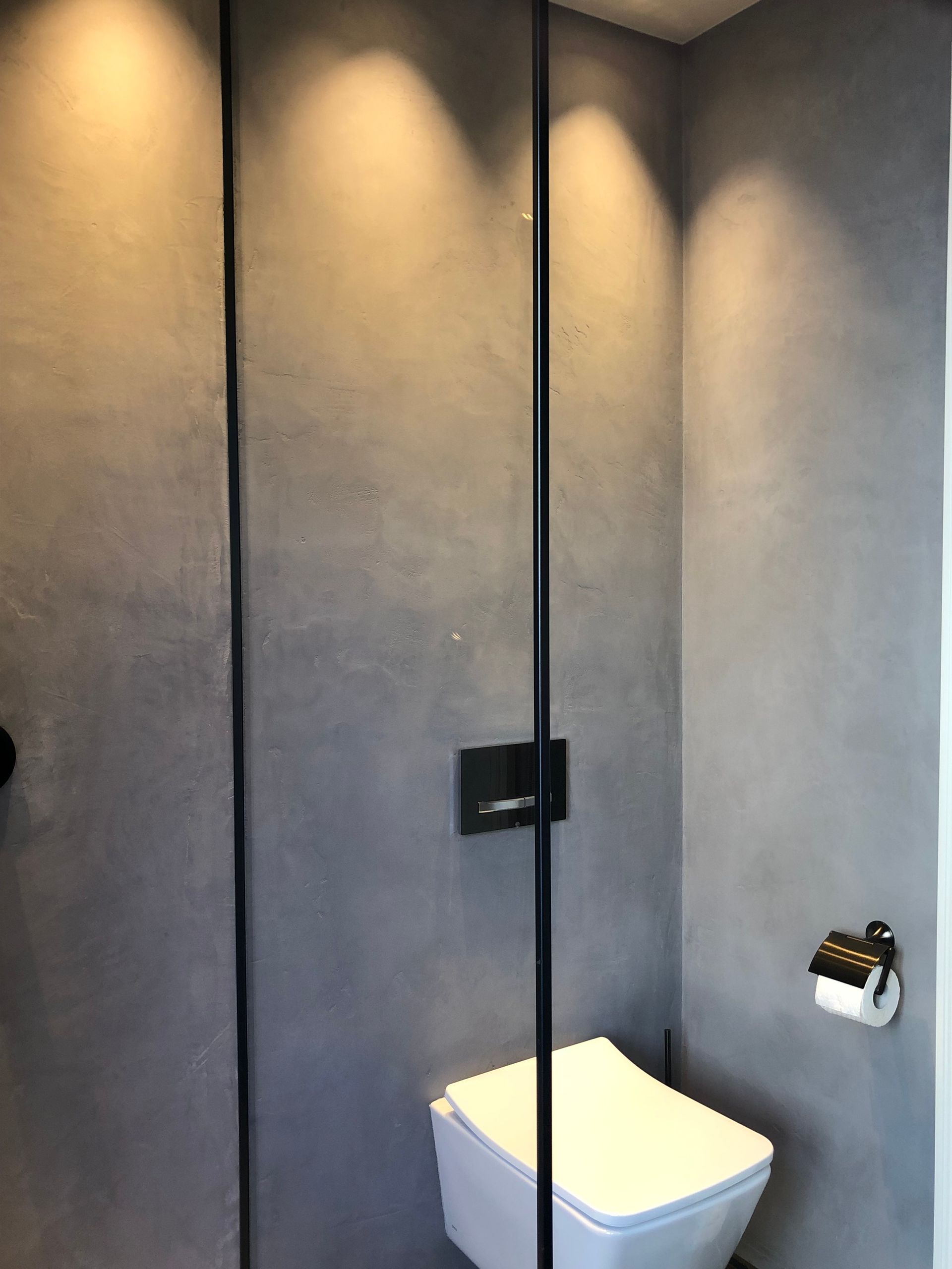 Ein Badezimmer mit Toilette und Glasduschtür.