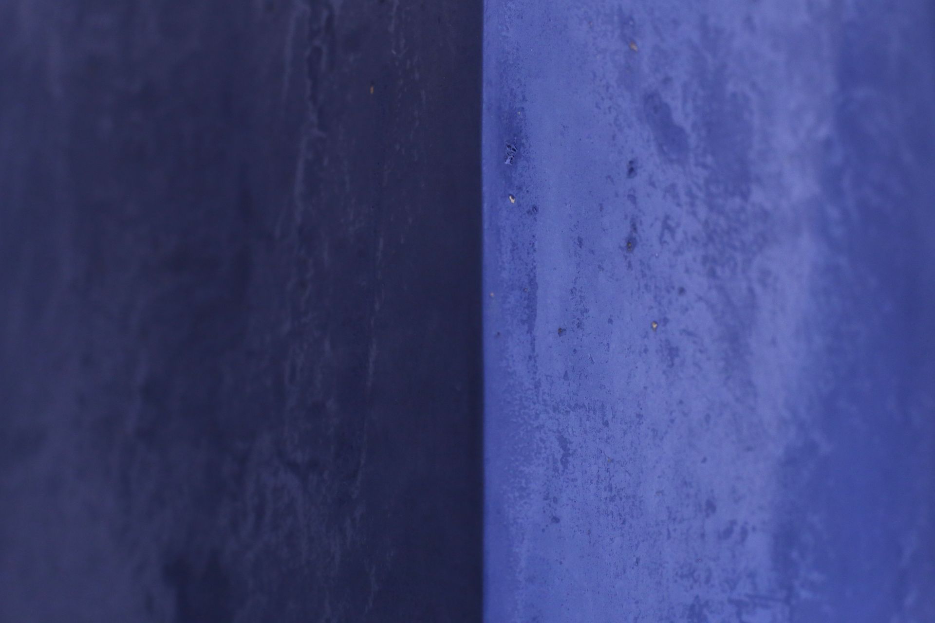 Eine Nahaufnahme einer blauen Wand mit violettem Hintergrund.