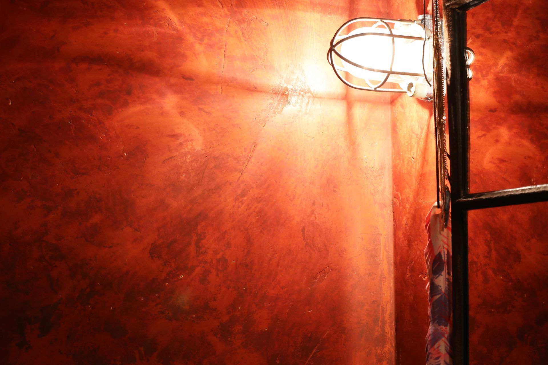 Ein Licht scheint auf eine rote Wand neben einer Leiter.
