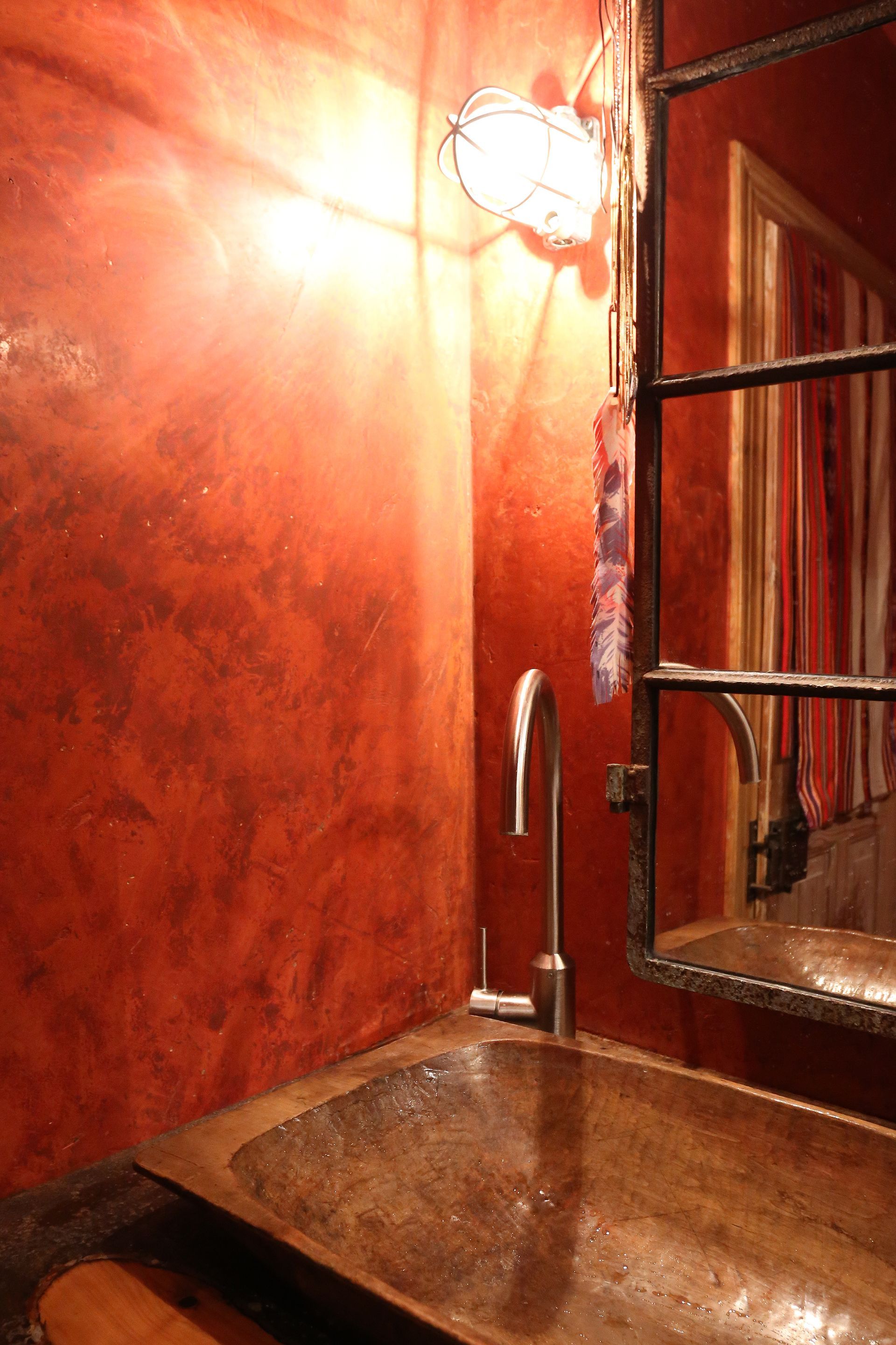 Ein Badezimmer mit roten Wänden und einem Waschbecken und Spiegel
