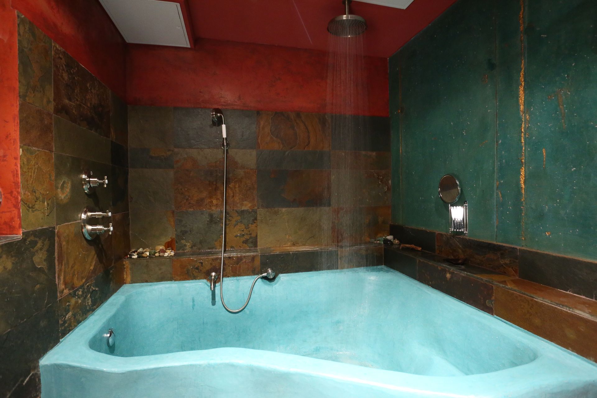 Ein Badezimmer mit einer blauen Badewanne und einer Dusche.