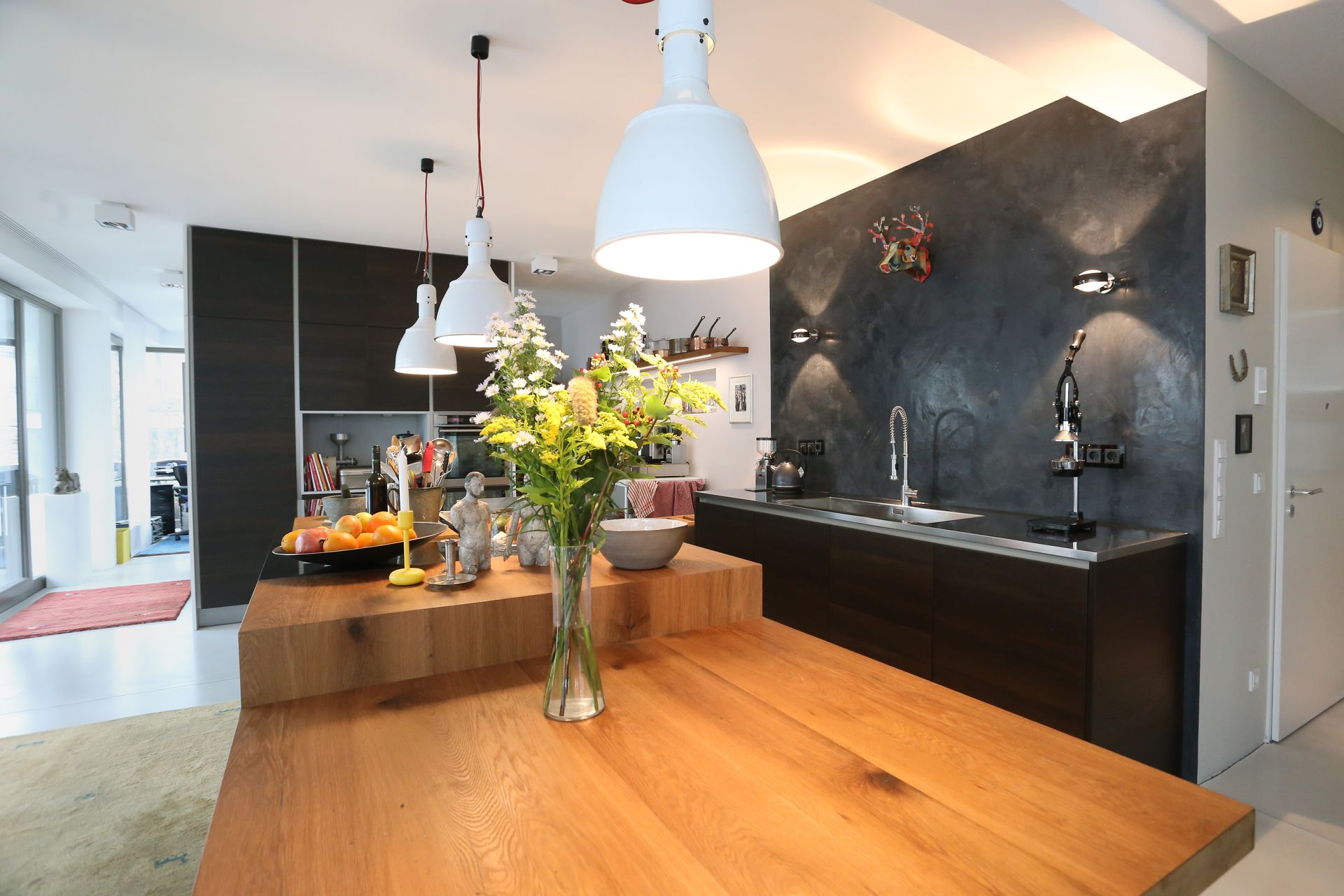 Eine Küche mit einem Holztisch und einer Vase mit Blumen darauf