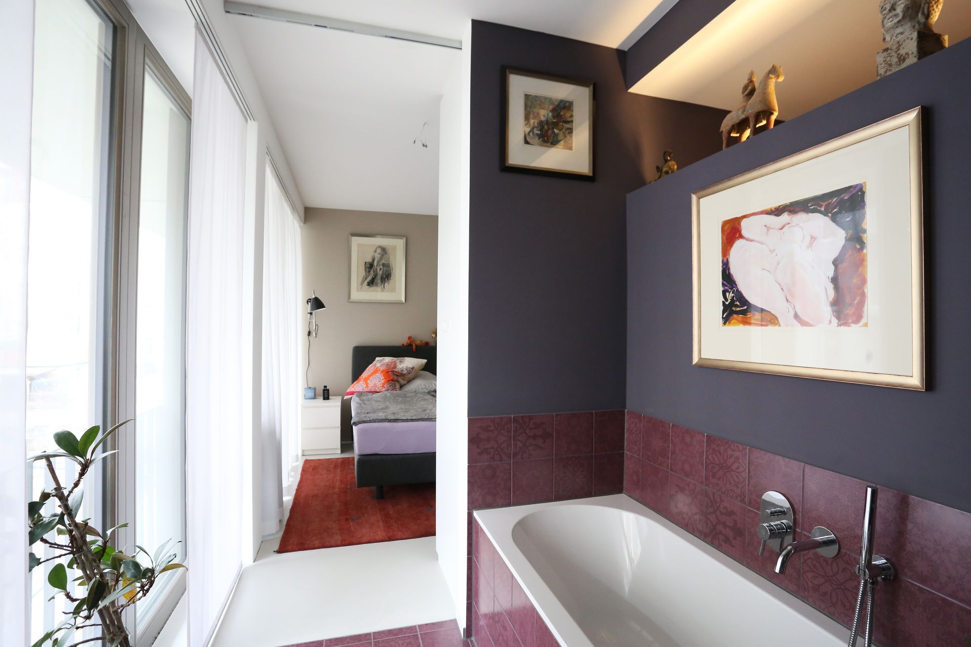 Ein Badezimmer mit Badewanne und einem Bild an der Wand