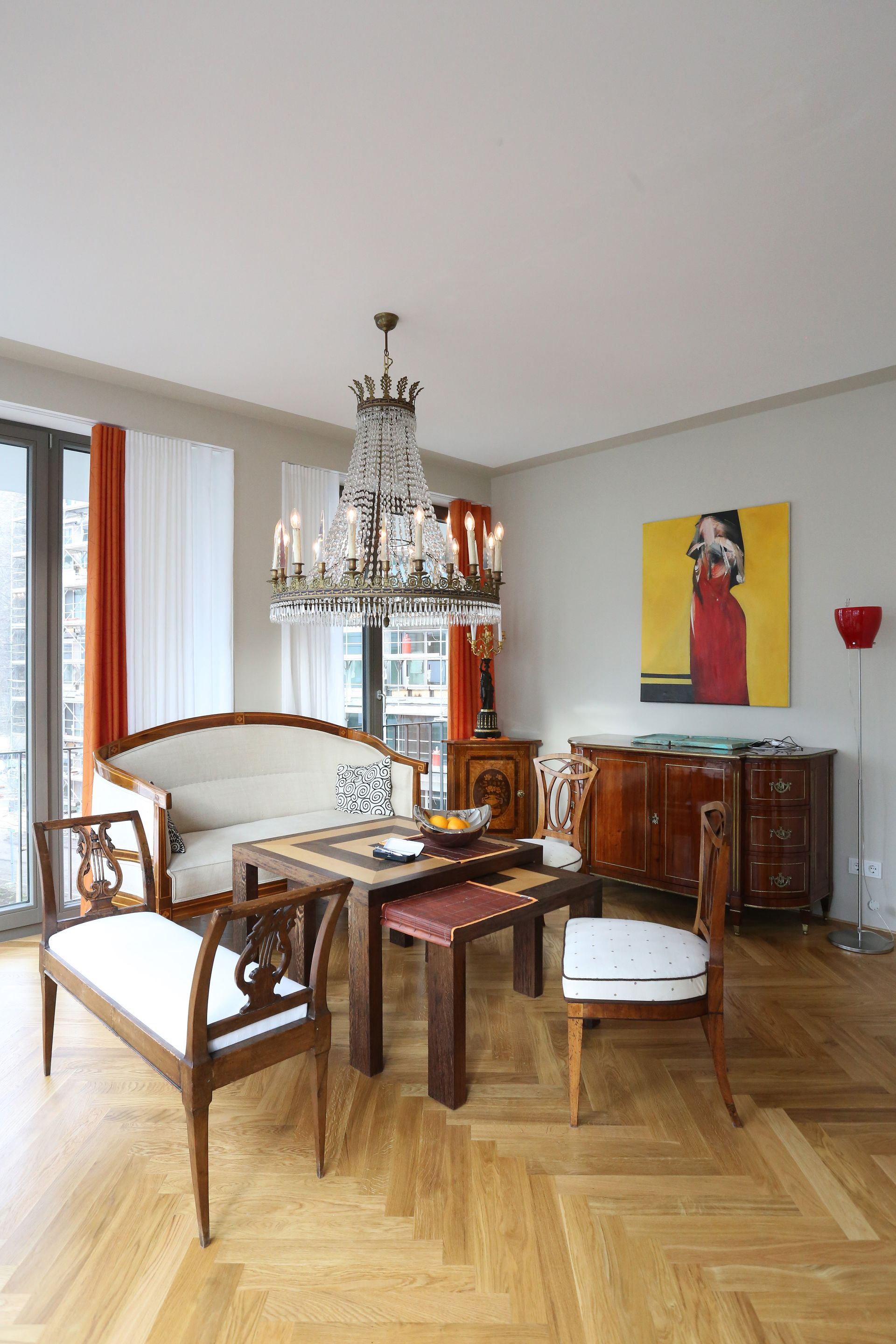 Ein Wohnzimmer mit Sofa, Stühlen, Tischen und einem Kronleuchter.