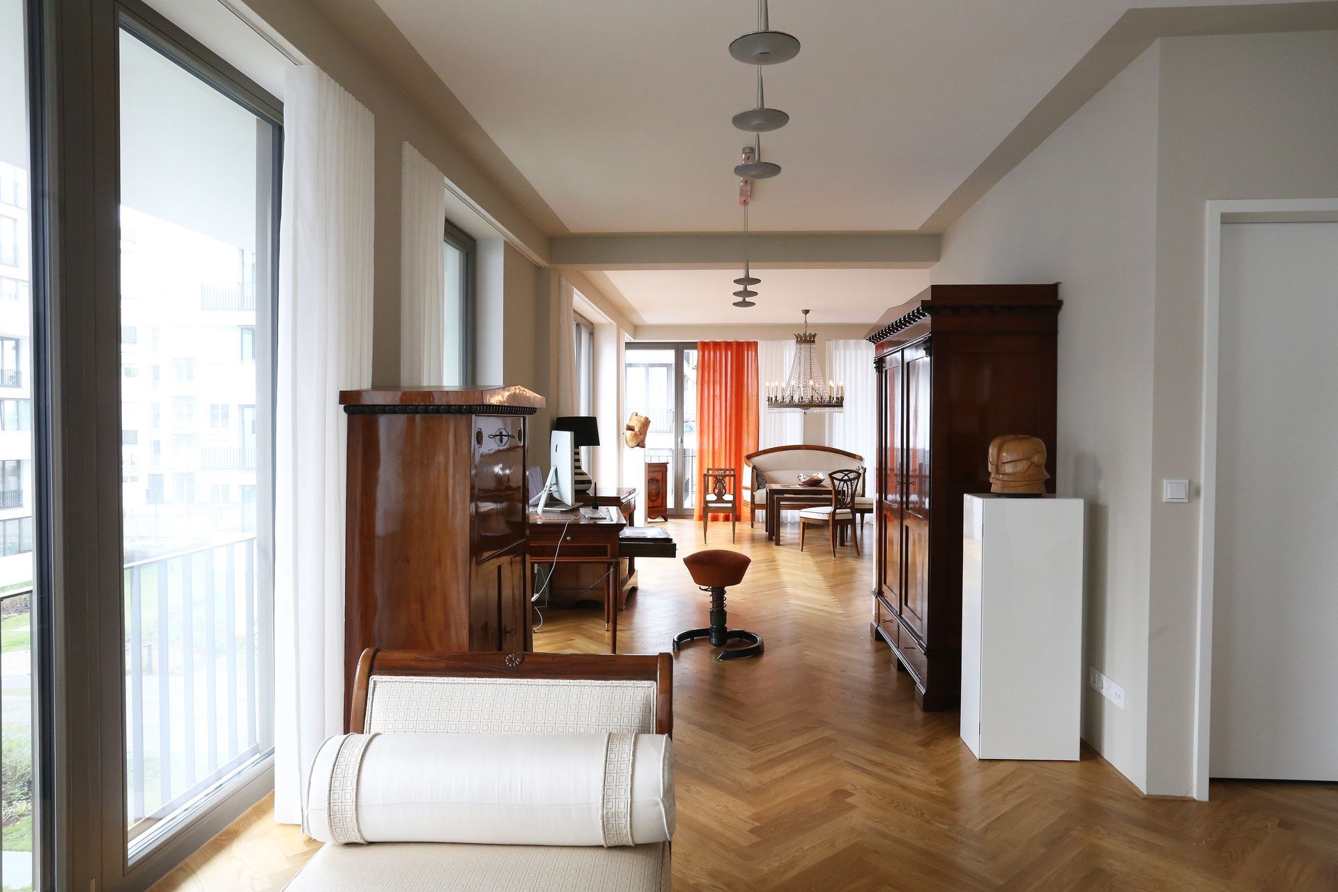 Ein Wohnzimmer mit Parkettboden und großem Fenster
