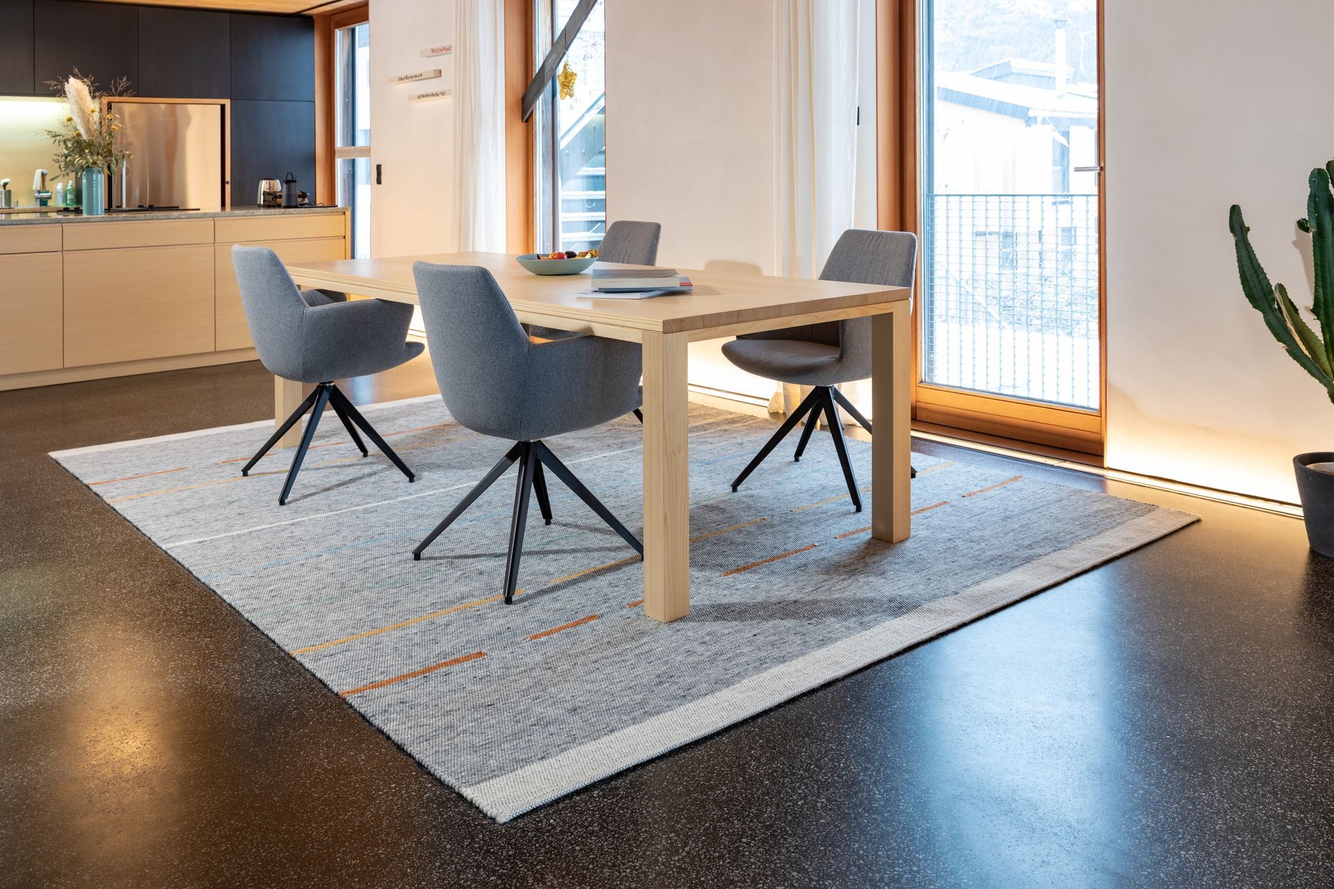 Ein Esszimmer mit Tisch und Stühlen und einem Teppich auf dem Boden.