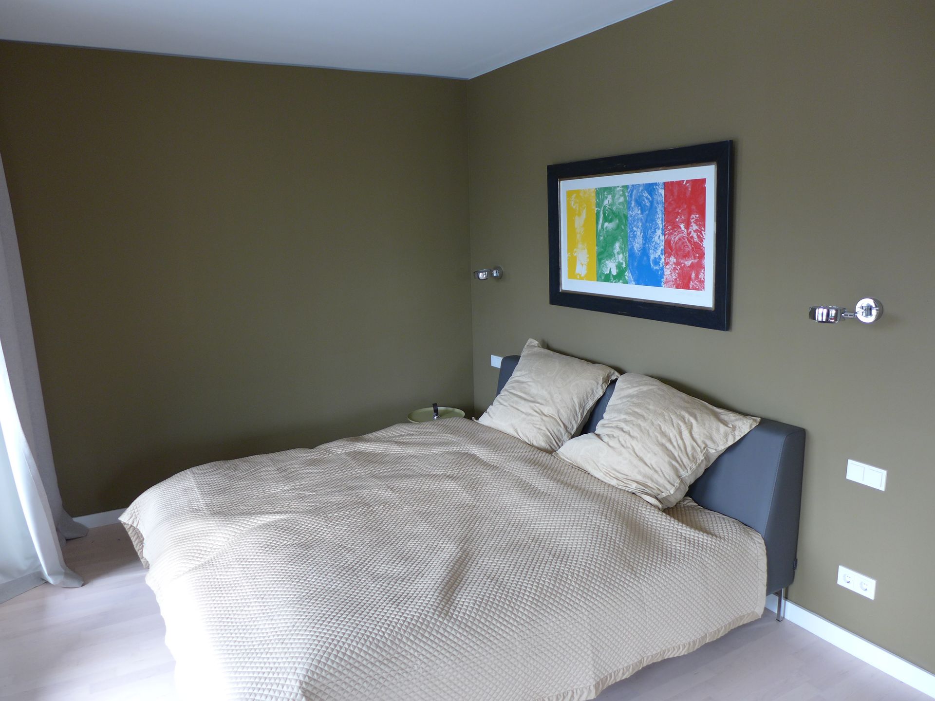 Ein Schlafzimmer mit einem Bett und einem Bild an der Wand darüber