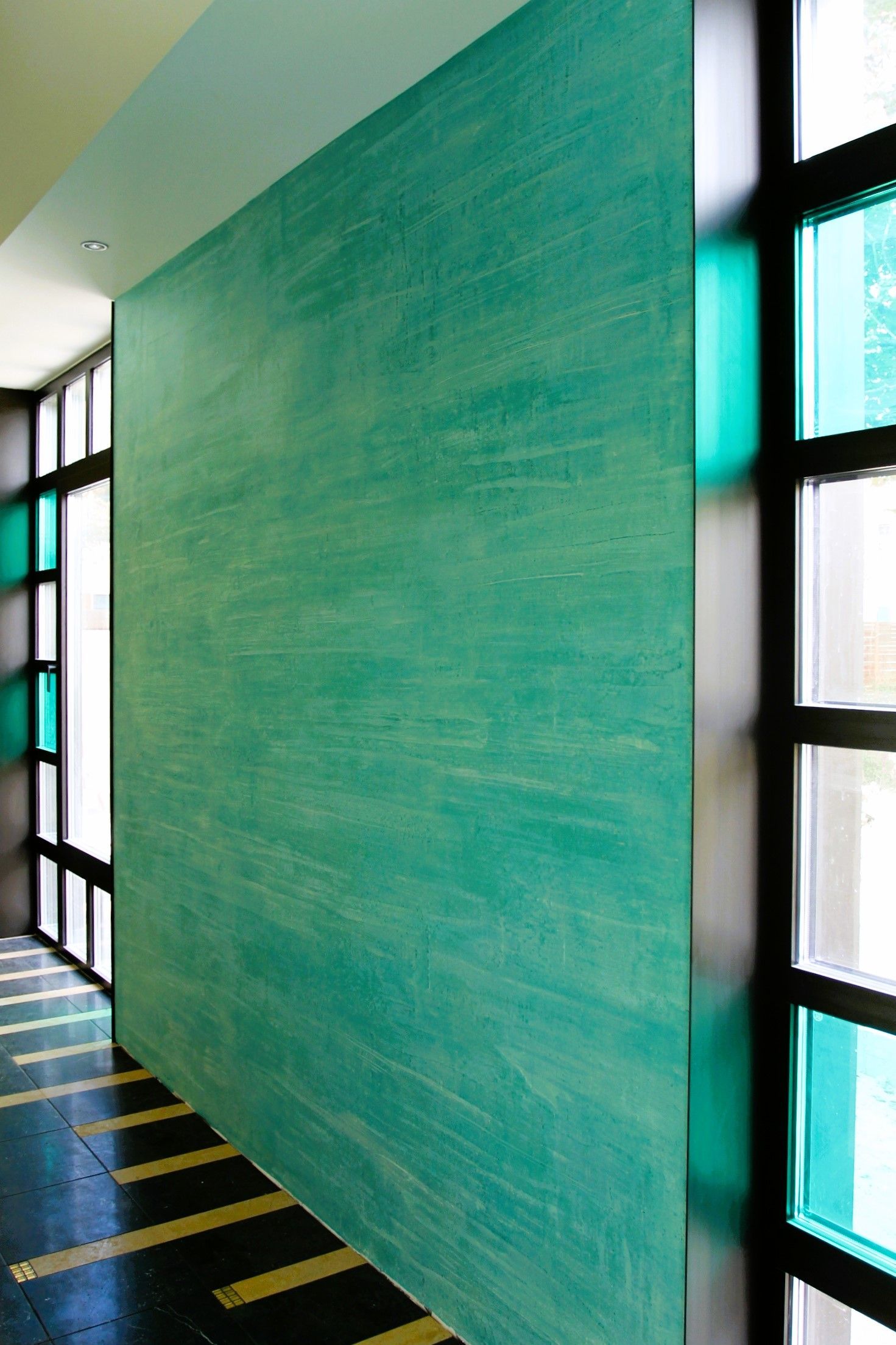 Eine grüne Wand in einem Flur neben einem Fenster
